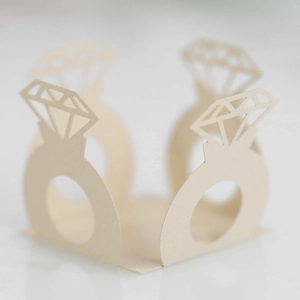 Macro detail of laser-cut hollow diamond ring paper wrappers for wedding candy decorations