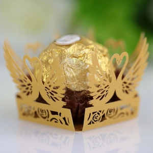 Macro shot of laser-cut golden swan chocolate holder with intricate rose details