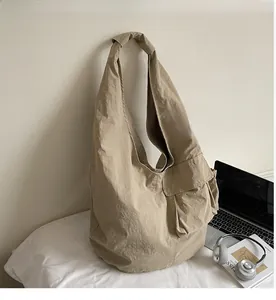 Detail of minimalist beige canvas tote bag with front pocket in casual indoor setting