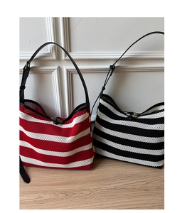 Détail de sacs fourre-tout rayés en maille avec motifs rouges et noirs et anses en cuir