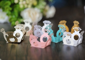 Laser-cut diamond ring shaped candy boxes on rustic wood for wedding decor