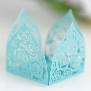 Macro detail of laser-cut rose patterns on a light blue decorative paper gift box