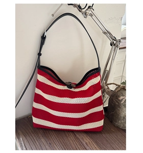 Détail macro du sac cabas en maille rayée rouge et blanc avec fermoir à bascule en bois