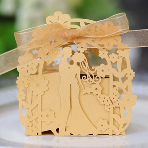 Macro detail of laser-cut golden wedding favor box with bride and groom silhouette