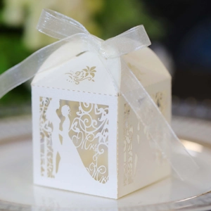Close-up of laser-cut Mr & Mrs wedding candy box with elegant white ribbon detail