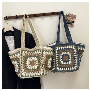 Handmade crochet tote bags with floral patterns on a wooden hanger in a home setting
