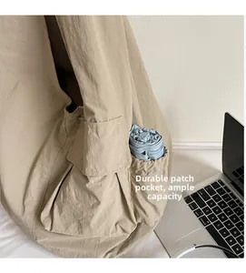 Detail of the nylon tote bag side pocket holding a blue umbrella for large capacity