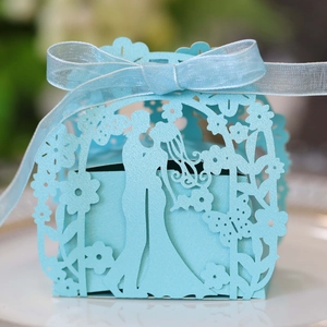 Detail of light blue laser cut wedding gift box with bride and groom silhouette and ribbon