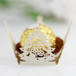 Detailed laser-cut white Christmas tree cupcake wrapper with golden chocolate