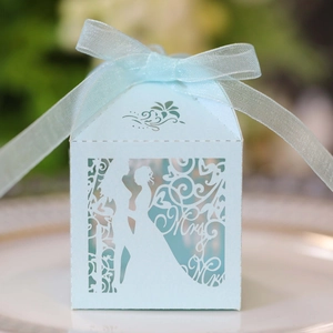 Close-up of light blue laser-cut candy box with Mrs silhouette and organza ribbon