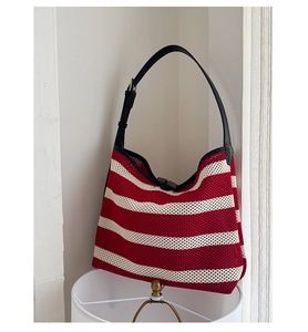 Détail du sac hobo en maille rayé rouge et blanc avec bandoulière en cuir noir