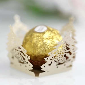 Macro view of laser-cut cream paper chocolate holder with hollow Christmas tree pattern