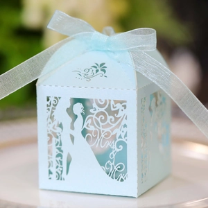 Detail of light blue laser-cut wedding favor box featuring Mr & Mrs silhouettes and ribbon