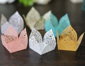 Laser-cut pink paper cupcake liners featuring rose floral patterns for chocolate and candy