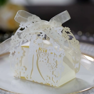 Detail of laser-cut ivory bridal silhouette on pearl paper wedding candy box with ribbon