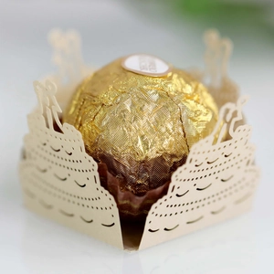 Macro shot of laser-cut cream chocolate paper wrapper with elegant cake and couple motifs