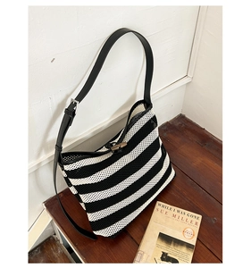 Détail du sac cabas tissé à rayures avec texture ajourée et fermoir en bois