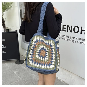 Detail of bohemian crochet tote bag featuring multi-colored granny square and blue straps