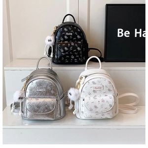 Detailed view of mini floral embossed backpacks in black, silver and white colors