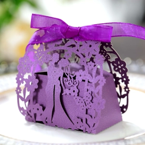 Detail view of purple laser-cut wedding candy box with couple silhouette and silk ribbon