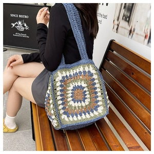 Close-up of handmade crochet sunflower tote bag with colorful granny square patterns