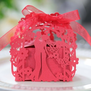 Detailed laser-cut red paper candy box with romantic silhouette and silk ribbon tie