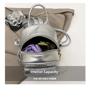 Silver metallic wrinkled mini backpack showing interior space and purple fabric lining
