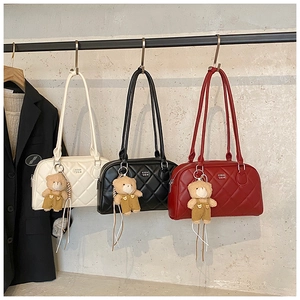 Close-up of three quilted tote bags in white, black and red with cute bear charms