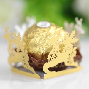 Dettaglio macro del porta cioccolato dorato tagliato al laser con renna e fiocchi