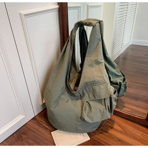 Macro shot of army green nylon tote bag with side pocket and natural wrinkled texture