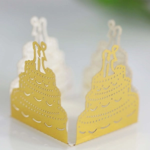 Macro detail of laser-cut gold wedding cake decoration with bride and groom silhouette