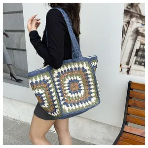 Close-up of bohemian crochet granny square tote bag with blue and beige knit patterns