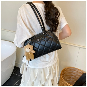 Détail du sac bandoulière matelassé noir avec logo et pendentif ours en peluche