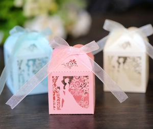 Close-up of laser-cut Mr & Mrs wedding candy boxes with delicate organza ribbons