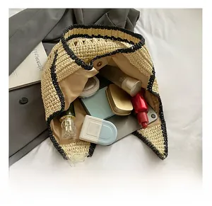 Detail view of the spacious interior of a woven straw bucket bag with daily essentials