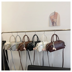 Detail of minimalist cylindrical shoulder bags in six colors with tulip pendants