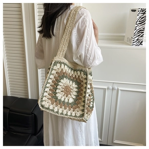 Detail of bohemian granny square crochet bag with floral pattern shown on shoulder