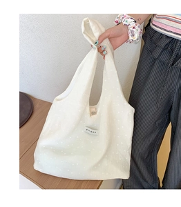 Close-up of white floral canvas tote bag with Korean label and integrated handle detail