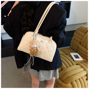 Detail of off-white quilted shoulder bag with cute brown plush bear charm and silver buckle