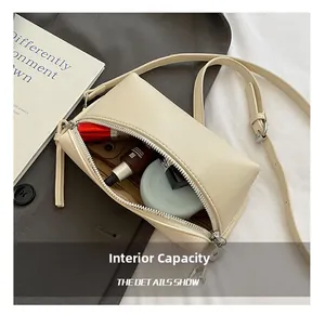 Interior storage space of the cream leather mini box bag showing lipstick and cosmetics