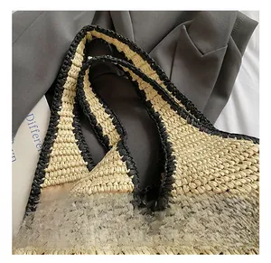 Detailed close-up of handmade woven straw tote handle with premium black trim and stitching