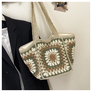 Detail of bohemian crochet tote bag with sunflower knit pattern and woven shoulder strap