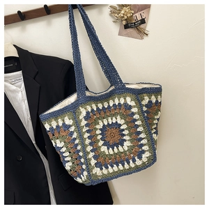 Detailed view of handmade crochet tote bag featuring vintage blue and beige knit patterns