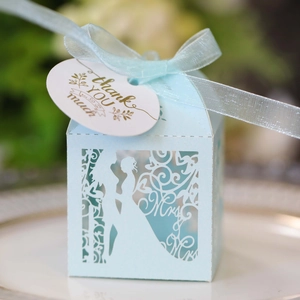Macro detail of laser-cut wedding favor box in light blue with elegant silk ribbon
