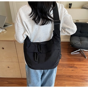 Detailed view of the black canvas crescent bag showing double zippers and adjustable strap