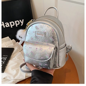 Dettaglio dello zaino mini argento floreale con ciondolo di peluche e cerniere metalliche