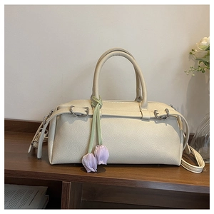 Detailed view of high-quality lychee grain leather texture on off-white boston handbag