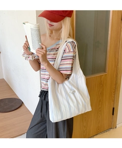 Detail of blue striped canvas tote bag with soft texture and white fabric label