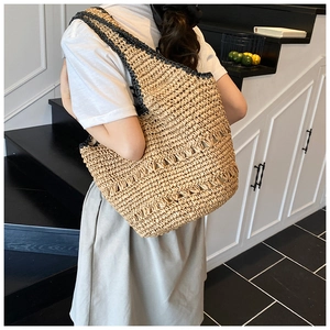 Detail showing the large capacity and natural texture of the summer straw bucket bag