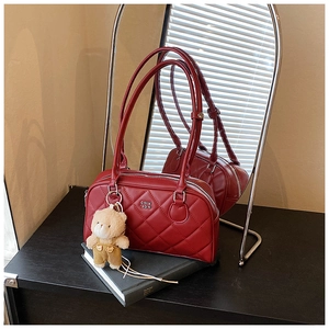 Détail du sac cabas matelassé rouge foncé avec logo et charmant pendentif ours
